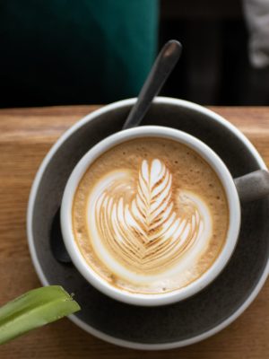 Gefüllte cappuchino Tasse mit leckerer Hafermilch und ansprechender Latte Art